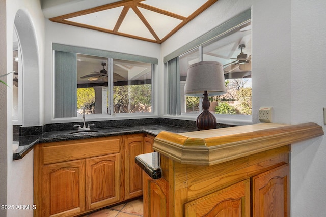 bar with sink, a wealth of natural light, and ceiling fan