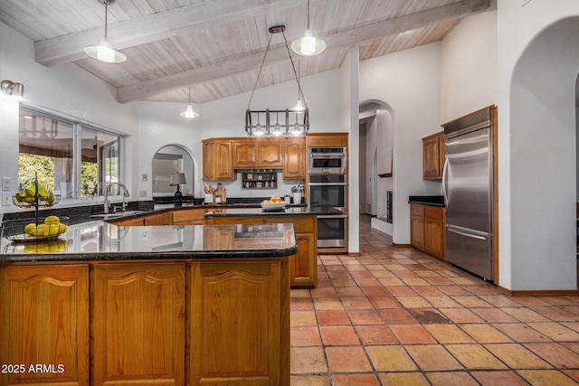 kitchen with sink, decorative light fixtures, kitchen peninsula, stainless steel appliances, and beam ceiling