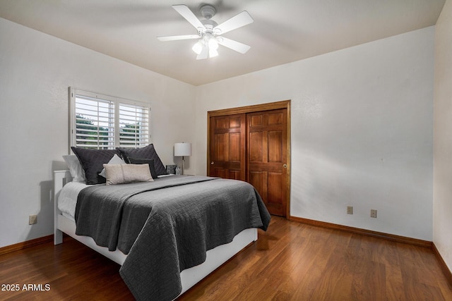 bedroom with dark wood-type flooring, ceiling fan, and a closet