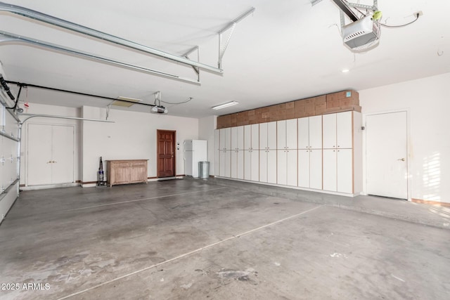 garage with a garage door opener and white fridge