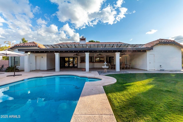 view of swimming pool with a yard, ceiling fan, and a patio area