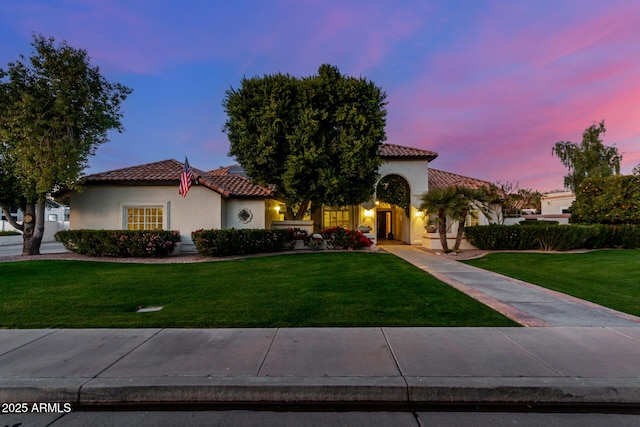 mediterranean / spanish home featuring a lawn