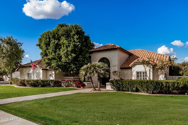 mediterranean / spanish-style home with a front yard