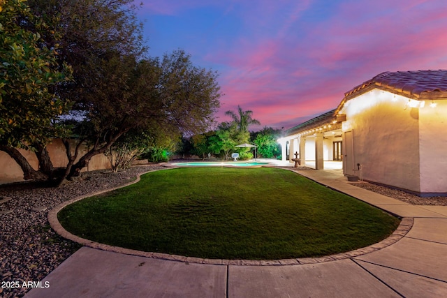 yard at dusk with a patio area