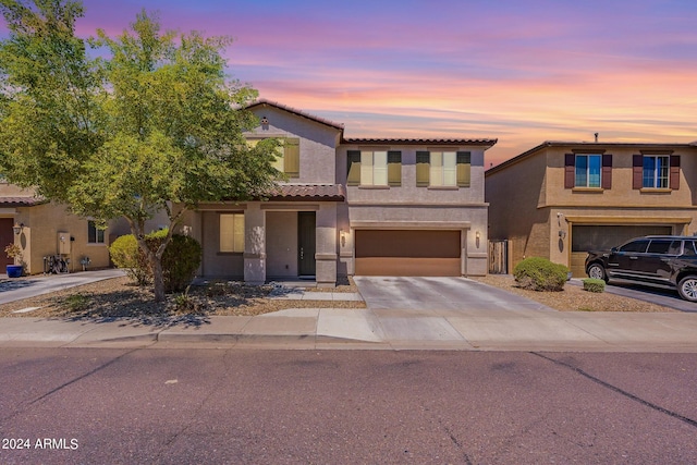 view of front facade featuring stucco siding, an attached garage, driveway, and a tiled roof