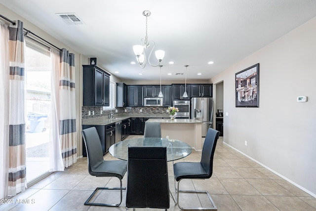 dining space featuring light tile patterned flooring, baseboards, visible vents, and a chandelier