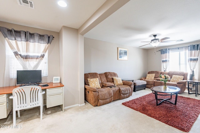 living room featuring ceiling fan, baseboards, visible vents, and light carpet