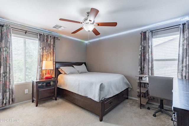 carpeted bedroom with visible vents, baseboards, and ceiling fan