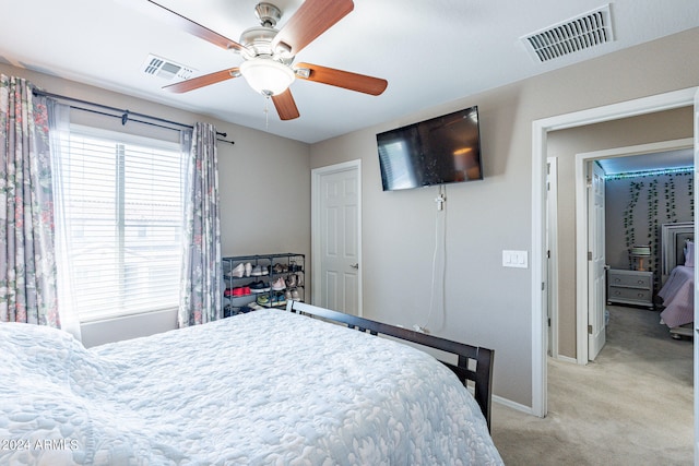 carpeted bedroom featuring multiple windows and ceiling fan