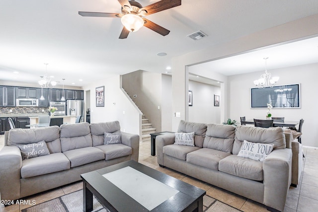 living area featuring visible vents, ceiling fan with notable chandelier, recessed lighting, light tile patterned floors, and stairs