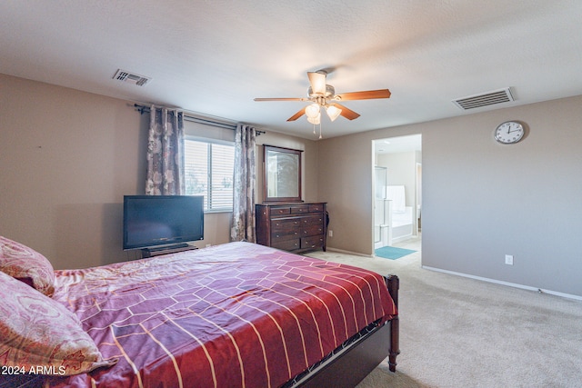 bedroom featuring ceiling fan, light carpet, and connected bathroom