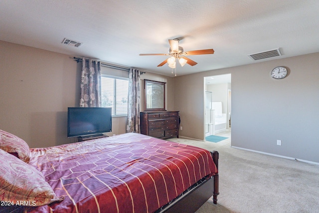 carpeted bedroom featuring visible vents, baseboards, ensuite bath, and a ceiling fan