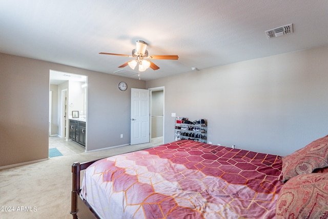 carpeted bedroom featuring ceiling fan and ensuite bathroom