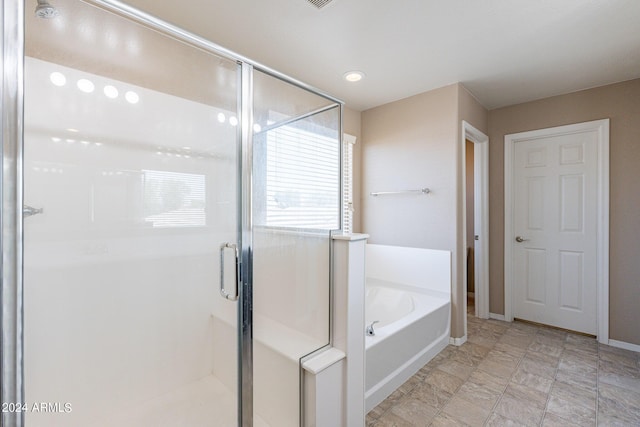 bathroom featuring a stall shower, baseboards, and a bath