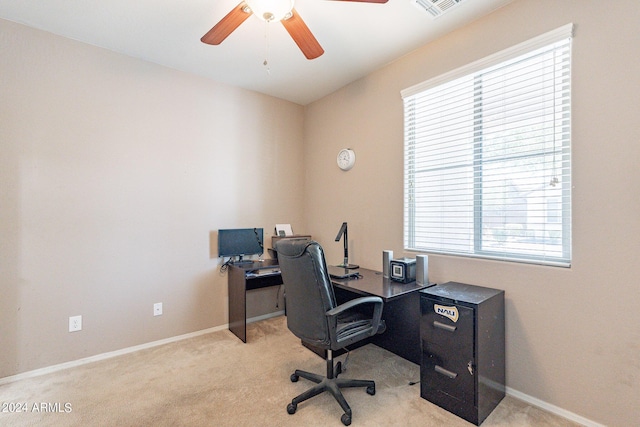 home office featuring visible vents, light colored carpet, a ceiling fan, and baseboards