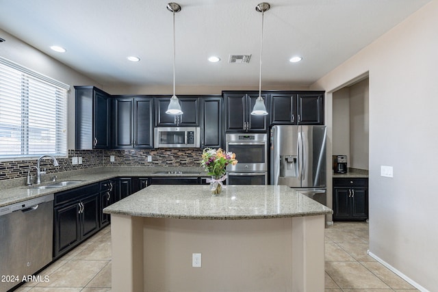 kitchen with a center island, stainless steel appliances, and light stone counters