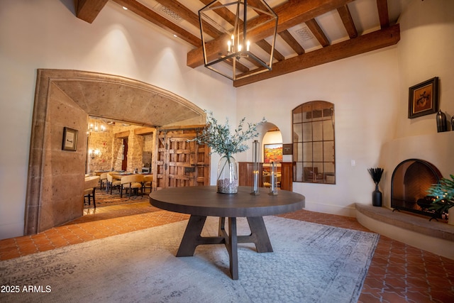 7751 E Golden Eagle Cir, Gold Canyon, AZ 85118 - dining area with beamed ceiling, arched walkways, a chandelier, a towering ceiling, and baseboards