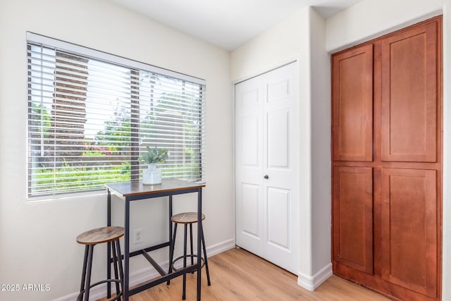 interior space featuring light wood-type flooring and baseboards