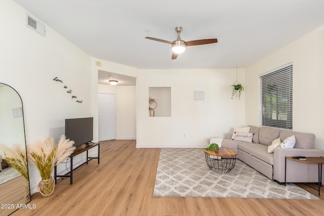 living area featuring visible vents, ceiling fan, baseboards, and light wood-style floors