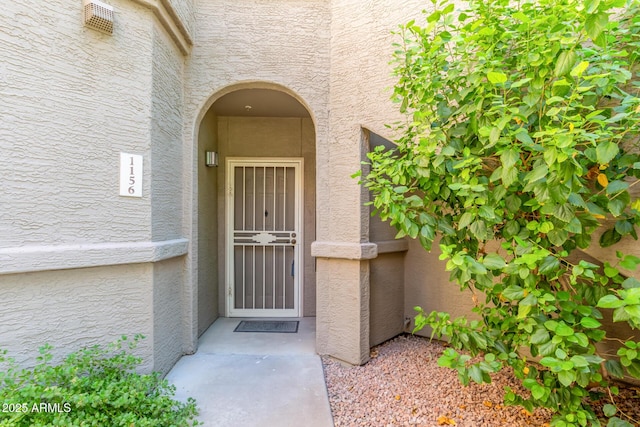 entrance to property featuring stucco siding