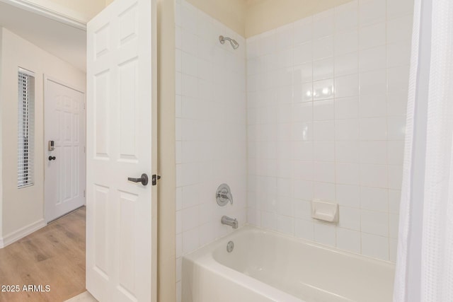 bathroom with shower / bathtub combination with curtain and wood finished floors