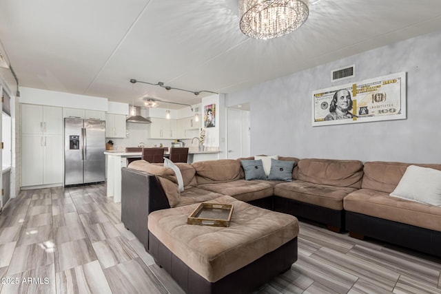 living room with an inviting chandelier and sink