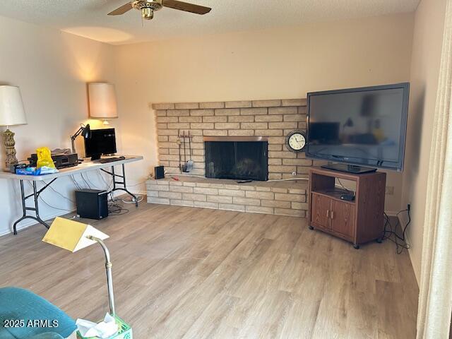 3242 W Christy Dr, Phoenix, AZ 85029 - living room with a fireplace, wood finished floors, ceiling fan, and a textured ceiling