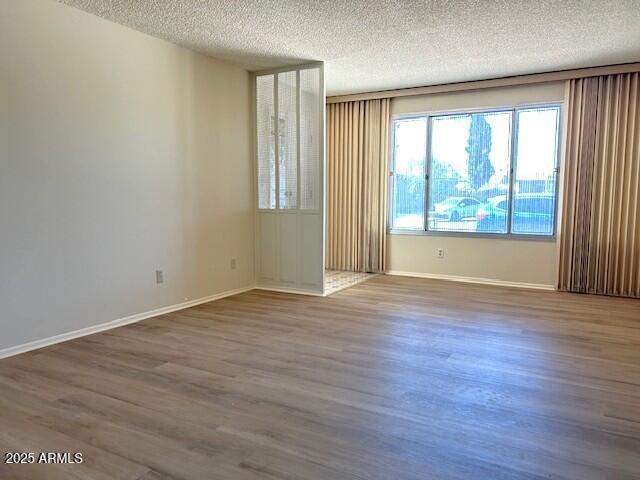 3242 W Christy Dr, Phoenix, AZ 85029 - unfurnished room with a textured ceiling, baseboards, and wood finished floors