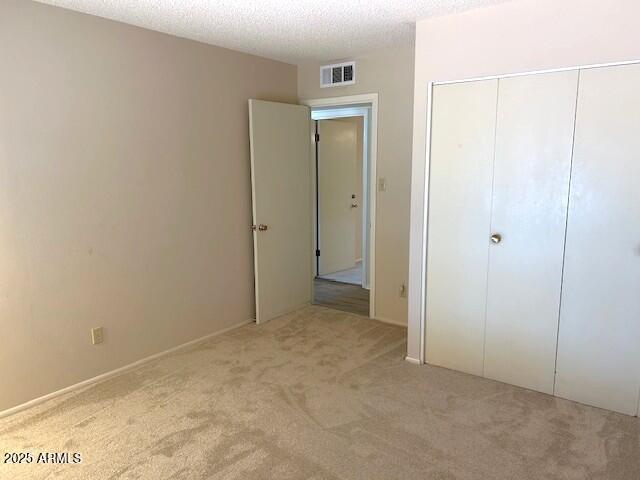 3242 W Christy Dr, Phoenix, AZ 85029 - unfurnished bedroom featuring a closet, a textured ceiling, visible vents, and carpet