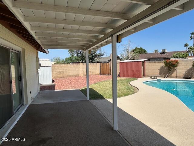3242 W Christy Dr, Phoenix, AZ 85029 - view of patio / terrace featuring an outdoor structure, a fenced backyard, and a fenced in pool