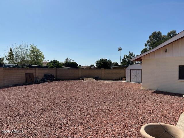 3242 W Christy Dr, Phoenix, AZ 85029 - view of yard featuring a storage unit, a fenced backyard, and an outdoor structure