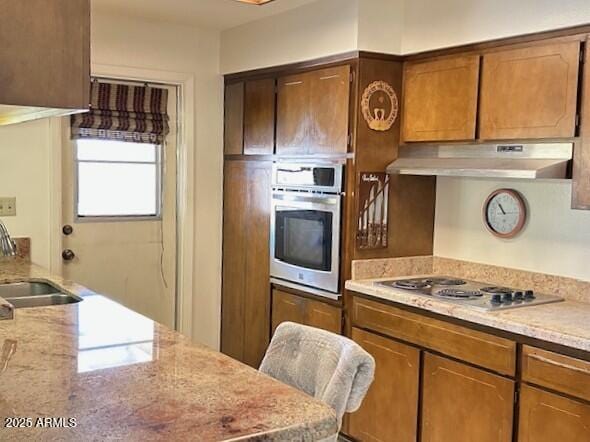 3242 W Christy Dr, Phoenix, AZ 85029 - kitchen with under cabinet range hood, a sink, stainless steel appliances, and brown cabinetry
