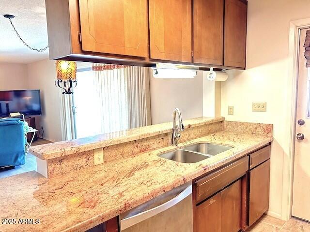 3242 W Christy Dr, Phoenix, AZ 85029 - kitchen featuring brown cabinets, a sink, light stone counters, and stainless steel dishwasher