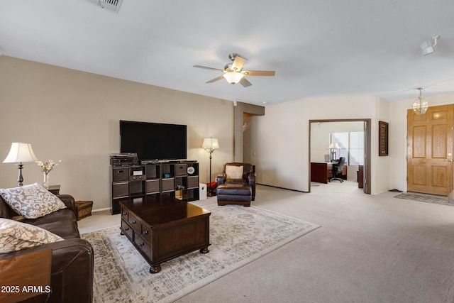 living room featuring light colored carpet and ceiling fan with notable chandelier