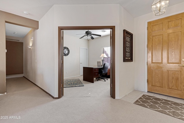 foyer entrance featuring light colored carpet and ceiling fan with notable chandelier