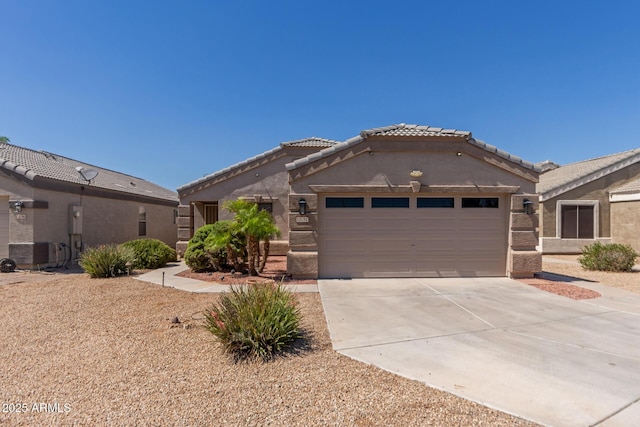 12132 W Caribbean Ln, El Mirage, AZ 85335 - view of front of home featuring an attached garage, driveway, a tiled roof, and stucco siding