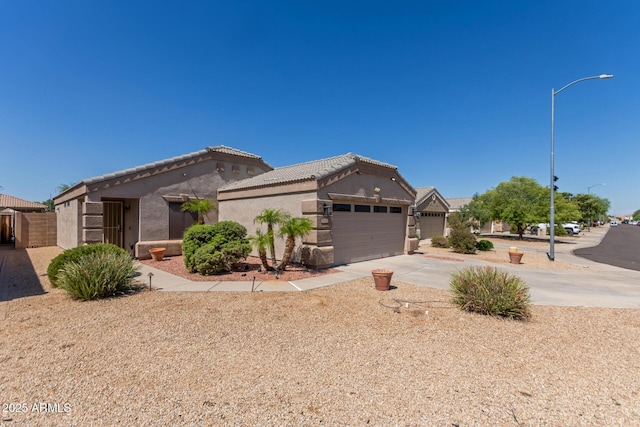 12132 W Caribbean Ln, El Mirage, AZ 85335 - view of front of property featuring stucco siding, driveway, an attached garage, and a tile roof