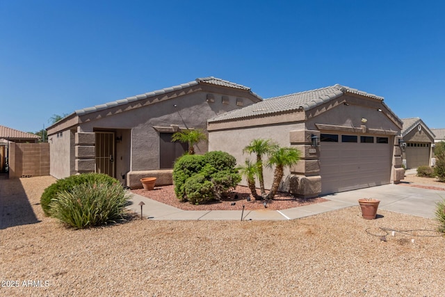 12132 W Caribbean Ln, El Mirage, AZ 85335 - view of front of home with an attached garage, driveway, stucco siding, and a tile roof