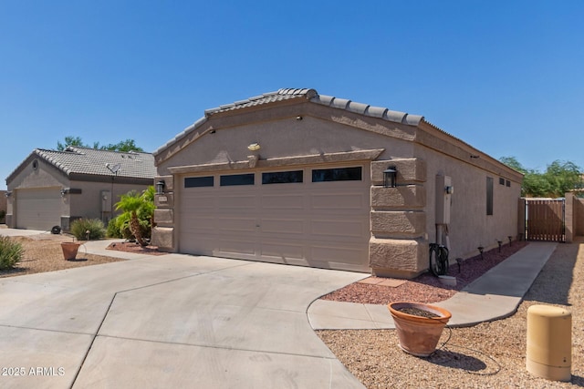 12132 W Caribbean Ln, El Mirage, AZ 85335 - view of front of home with driveway, a garage, a gate, and stucco siding