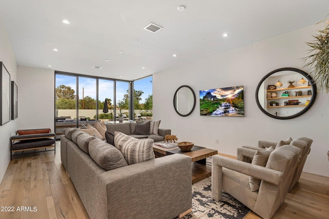 living room featuring floor to ceiling windows and light hardwood / wood-style floors