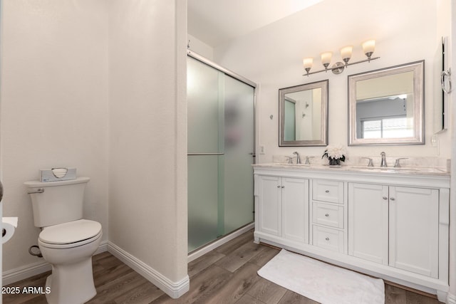 bathroom featuring vanity, hardwood / wood-style floors, a shower with shower door, and toilet