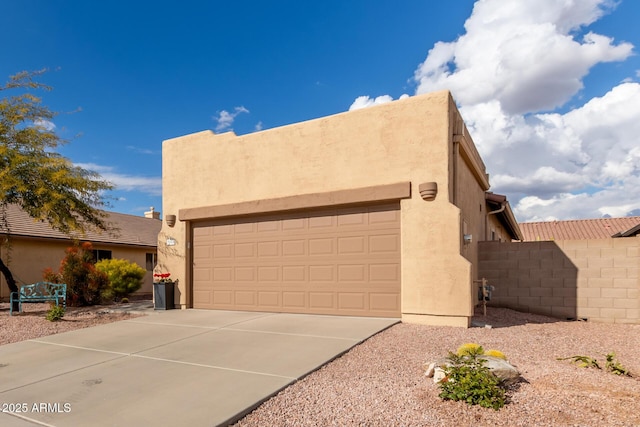 pueblo-style house featuring a garage