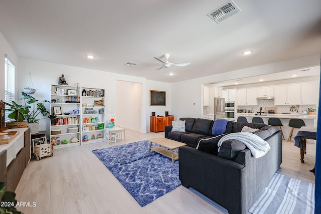 living room with light wood-type flooring and ceiling fan