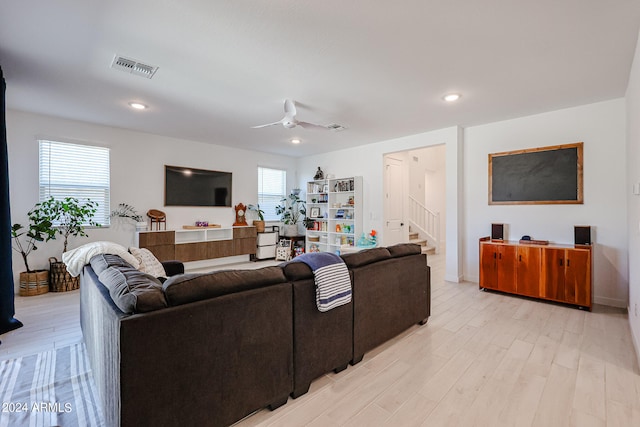 living room with light hardwood / wood-style flooring, ceiling fan, and plenty of natural light