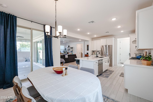 dining room featuring an inviting chandelier, light hardwood / wood-style floors, and sink