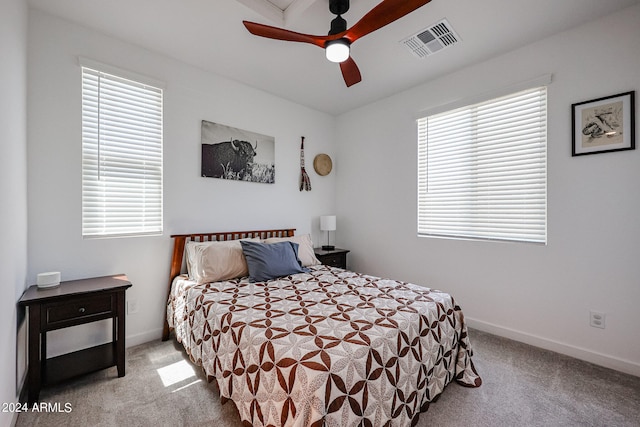 bedroom featuring light carpet, multiple windows, and ceiling fan