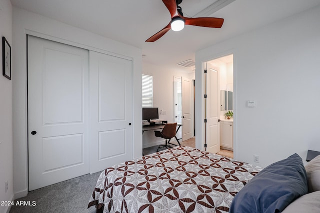 bedroom with a closet, ceiling fan, ensuite bathroom, and carpet floors