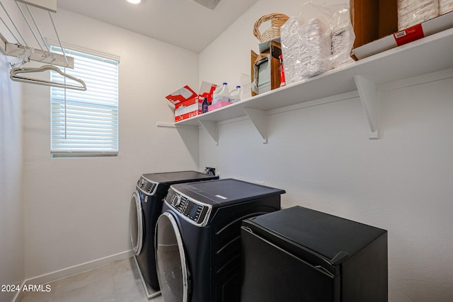 washroom with separate washer and dryer and light tile patterned floors