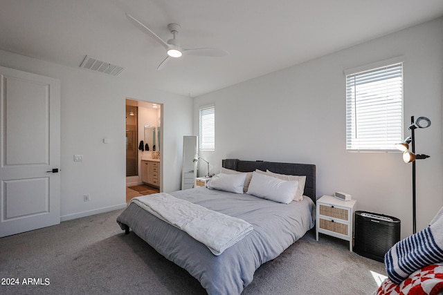 carpeted bedroom with ensuite bath and ceiling fan