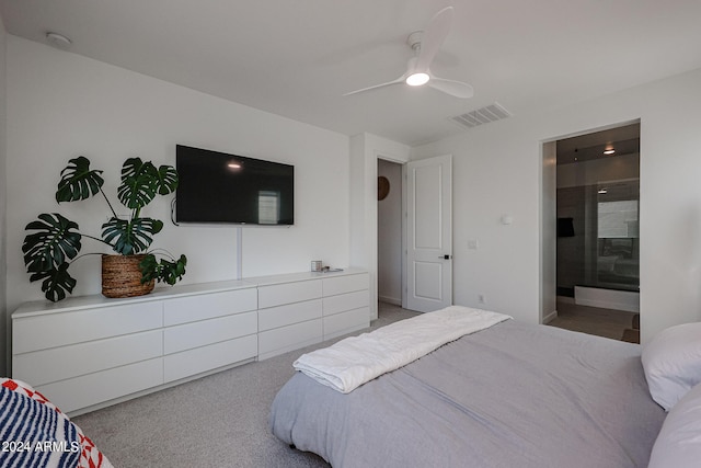 bedroom with light carpet, ensuite bath, and ceiling fan